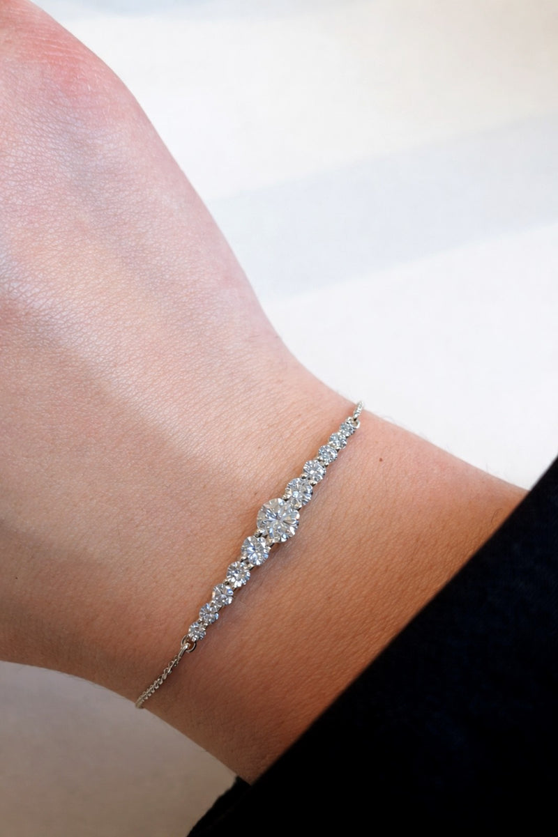 Silver bracelet with diamonds on a wrist against a white background